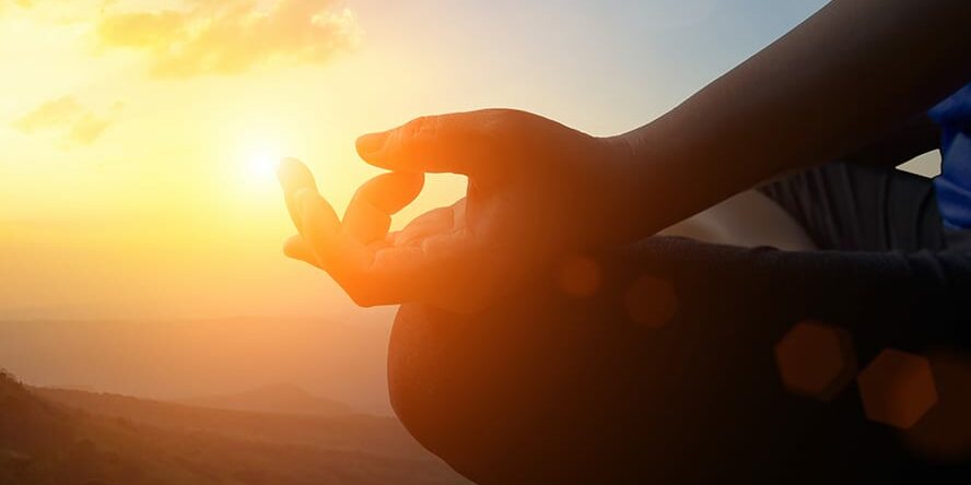 Young women meditate while doing yoga meditation, spiritual mental health practice with silhouette of lotus pose having peaceful mind relaxation on mountain outdoor with sunset golden heavenly sky.